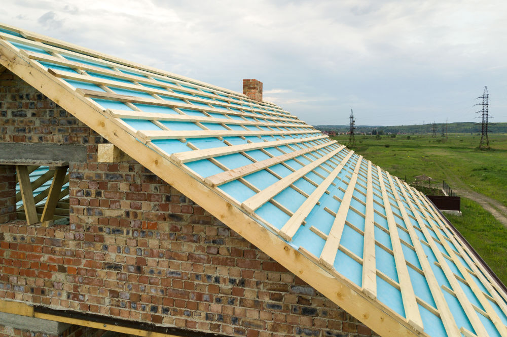 Aerial view of a brick house with wooden roof frame under constr Couvreur Toulouse